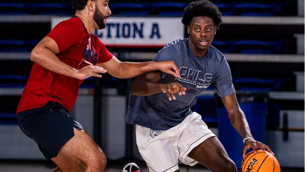 Franck Belibi Jr. dribbling at practice with Assistant Coach Demond Parker