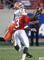 Illinois receiver Greg Lewis<br>watches a long pass from<br>quarterback Kurt Kittner<br>fall off his<br>fingertips as Louisville<br>defender Antonio Roundtree<br>closes in.