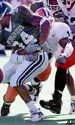Safety Bobie Singleton strips the ball away from Michigan State tailback Tyrell Dortch.