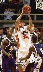 Illinois' Brian Cook, center, pulls down a rebound between Western Illinois' Johnny Johnson, left, and Brian Williams during the first half.
