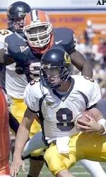 Cal quarterback Aaron Rodgers is chased by Derrick Strong during the first half.