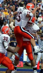 Illinois quarterback Tim Brasic (15) leaps into the arms of teammate Russ Weil as Pierre Thomas (30) and Jason Davis (34) look on after Brasic's rushing touchdown against California in the first half. (AP Photo/Marcio Jose Sanchez)