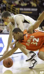 Demetri McCamey fights for a loose ball with Iowa's Jake Kelly during the first half. (AP Photo/Charlie Neibergall)