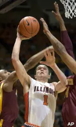 Trent Meacham slides between Minnesota's Al Nolen and Damian Johnson for a shot during the first half. (AP Photo/Robert K. O'Daniell)