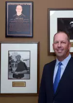 Illinois head men's golf coach Mike Small with his commemorative plaque at the Illinois Golf Hall of Fame induction ceremony.