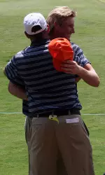 Head coach Mike Small congratulates Charlie Danielson on his match-clinching 20-foot par putt on the 18th hole.