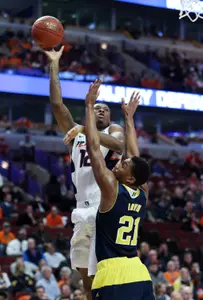 Illinois Fighting Illini forward Leron Black (12) shoots over Michigan Wolverines guard/forward Zak Irvin (21) during the first half in the second round of the Big Ten Conference Tournament at United Center. Mandatory Credit: Jerry Lai-USA TODAY Sports