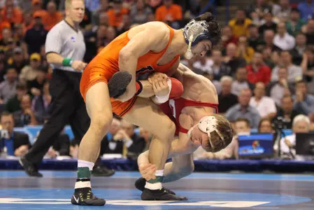 Illinois' Isaiah Martinez pulls on the leg of Cornells' Brian Realbuto during the 157 pound class match of the 2015 NCAA Division 1 Wrestling Championships at the Scottrade Center in St. Louis on March 21, 2015. Photo by Bill Greenblatt/UPI