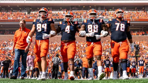 CHAMPAIGN, IL - September 16, 2023 - Honorary Captain Stu Levenick, Illinois Tight End Tip Reiman (#89), Illinois Quarterback John Paddock (#4), Illinois Defensive Tackle Keith Randolph Jr. (#88), and Illinois Offensive Lineman Isaiah Adams (#78) before the game between the Penn State Nittany Lions and the Illinois Fighting Illini at Memorial Stadium in Champaign, IL. Photo By Patrick Pierson