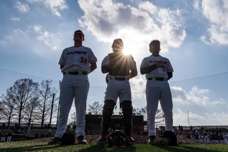 CHAMPAIGN, IL - February 27, 2024 - Illinois Infielder Drake Westcott (#34), Illinois Catcher Camden Janik (#17) and Illinois Left Handed Pitcher Cooper Omans (#27) during the National Anthem before the game between the Eastern Illinois Panthers and the Illinois Fighting Illini at Illinois Field in Champaign, IL. Photo By Kevin Snyder
