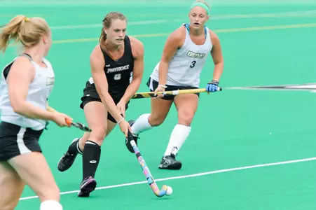 Field Hockey midfielder Caitlin Malone advances with the ball upfield while she is surrounded by Bryant defenders during their matchup at Lennon Family Field.