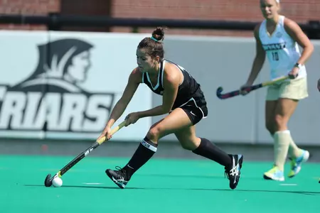 Megan Hamilton passes the ball in a field hockey game versus Bryant
