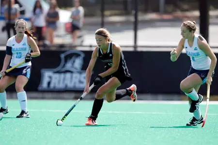 Field Hockey forward Izzy Mendez takes the ball up field while being trailed by a Maine defender at Lennon Family Field.