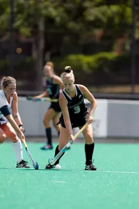 Field Hockey forward Allie Lancaster tales the ball up field while being pressured by a defender during a game at Lennon Family Field.