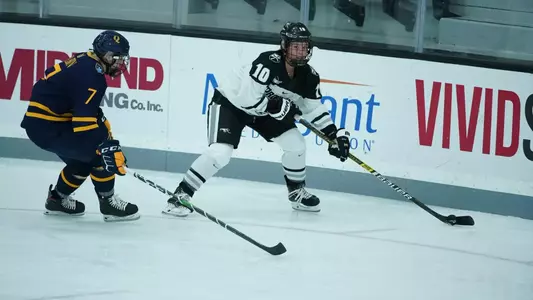 Women's ice hockey player Neve Van Pelt skating with the puck during a game
