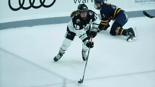 Women's ice hockey player Maureen Murphy skating with the puck during a game
