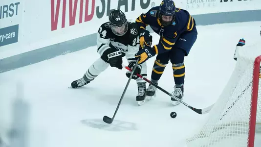 Women's ice hockey player Hayley Lunny battling for the puck behind the net