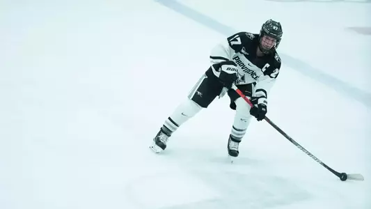 Women's ice hockey player Avery Fransoo skating with the puck during a game