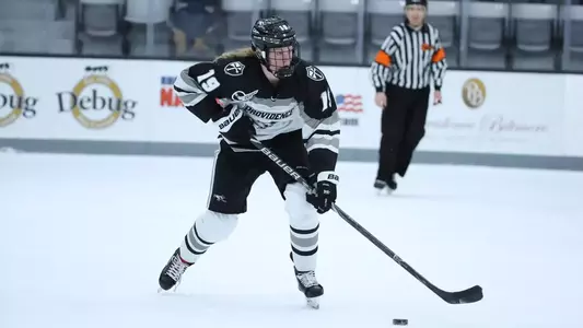 A photo of women's ice hockey player Sara Hjalmarsson skating up the ice with the puck during a game
