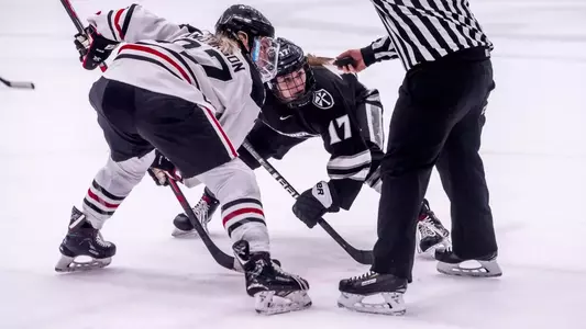 A photo of women's ice hockey player Cassidy MacPherson getting ready to take a faceoff during the Hockey East semifinals