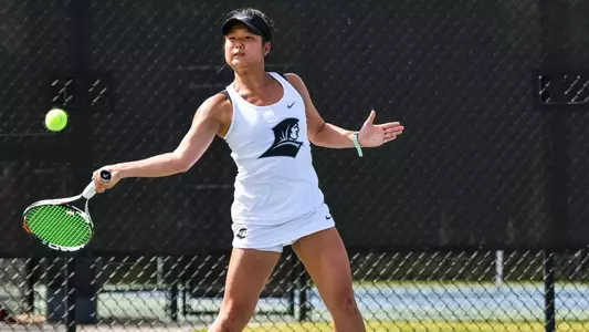 Tennis Player Risa Takenaka hits the ball forehand during a 2019 outdoor match.