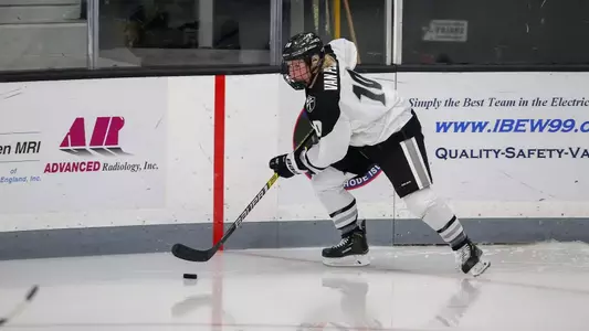 Women's ice hockey player Neve Van Pelt skating with the puck during a game