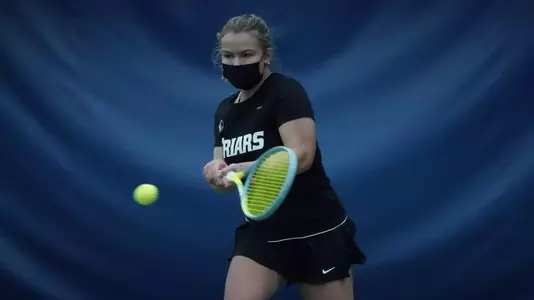 Tennis player Emmie Lindholm hits the ball in a 2021 match.