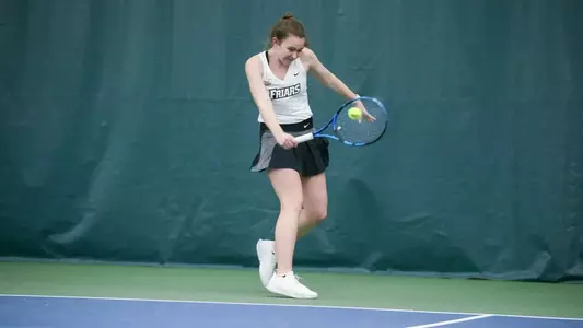 Tennis player Lauren Carson hits the ball during a 2022 indoor match.