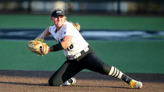 Jacque Harrington in the middle of throwing a softball against St. John's.