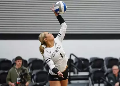 Miller McDonald hitting a ball over her head in a game against DePaul during the 2023 season