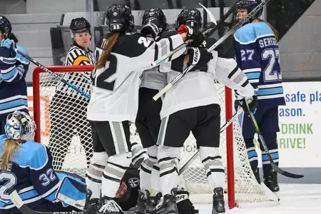 Women's Ice Hockey team celebrating together after scoring a goal