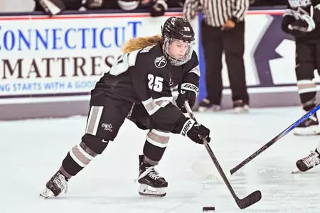 Women's Ice Hockey player Hannah Johnson skating with the puck during a game