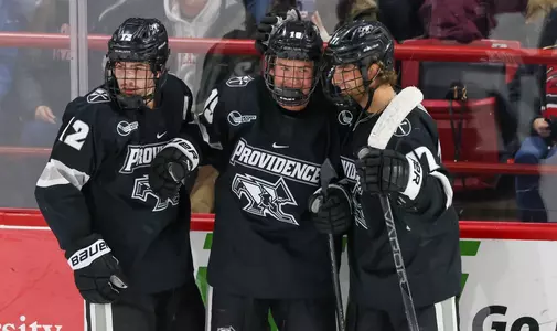 Men's Hockey - Tanner Adams, Nick Poisson and Chase Yoder celebrate at Northeastern