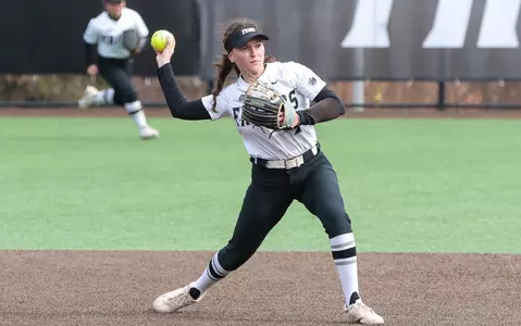 Rachael Petrarca throwing a ball in a softball game.