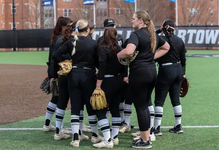 Softball Team in huddle on Glay Field