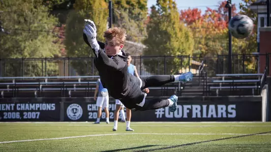 Ryan Carney men's soccer mid-air in goal action shot