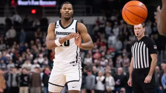 Rich Barron men's basketball passes the ball to teammate in game against St. Johns