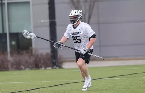 Grant Latimer cradling the ball on Chapey Field in Anderson Stadium in 2024 home game.