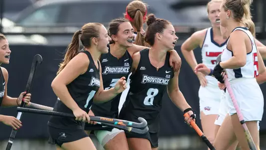 Field hockey midfielders Cami Crook, Hannah McKenney, and Carly van Benten are pictured celebrating after a goal is scored against Liberty at Lennon Field.