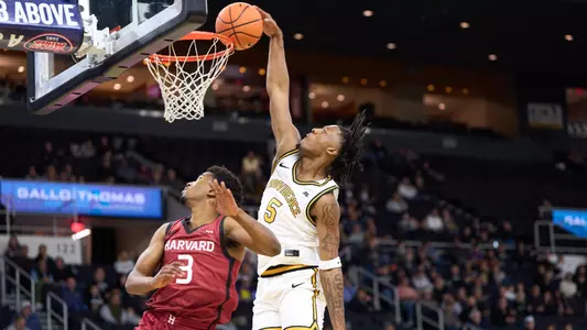 Freshman forward Jamier Jones is pictured dunking on a Harvard player in their exhibition game