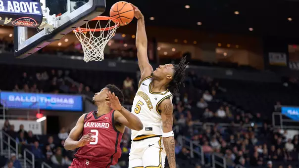 Freshman forward Jamier Jones is pictured dunking on a Harvard player in their exhibition game