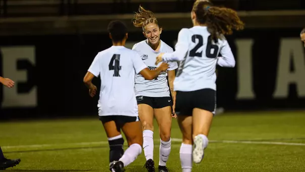 Lily Gibbs celebrates goal with Amaya Coffie and Ella McBride versus Marquette on Chapey Field at Anderson Stadium