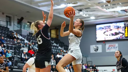 Audrey Shields shoots the ball over a defender from Franklin Pierce.
