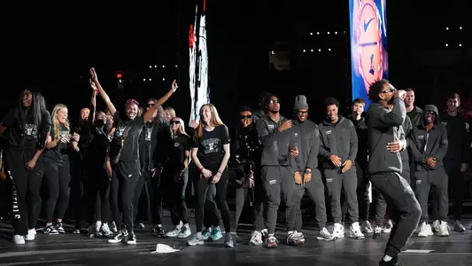 Men's and women's basketball teams dance on stage at Late Night Madness at the Amica Mutual Pavilion.