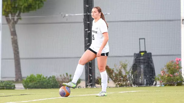 Women's soccer player Stephanie Schoeley has foot on top of ball waiting to play a free kick on Chapey Field at Anderson Stadium.