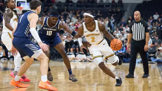 Jaylin Sellers drives through a double-team off of a screen versus the University of New Hampshire