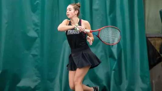Tennis player Mae Abreu follows through with a forehand swing during a 2025 indoor match.