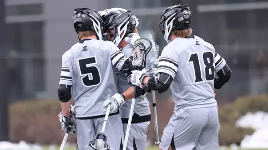 Lacrosse attack players celebration after scoring a goal versus Harvard.