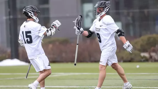 Ryan Bell and Richie Joseph fist bump to celebrate a goal.