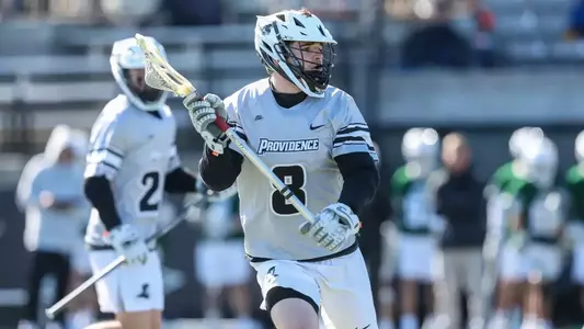 Lacrosse player Quinn McConnaughey with the ball versus Loyola Maryland.